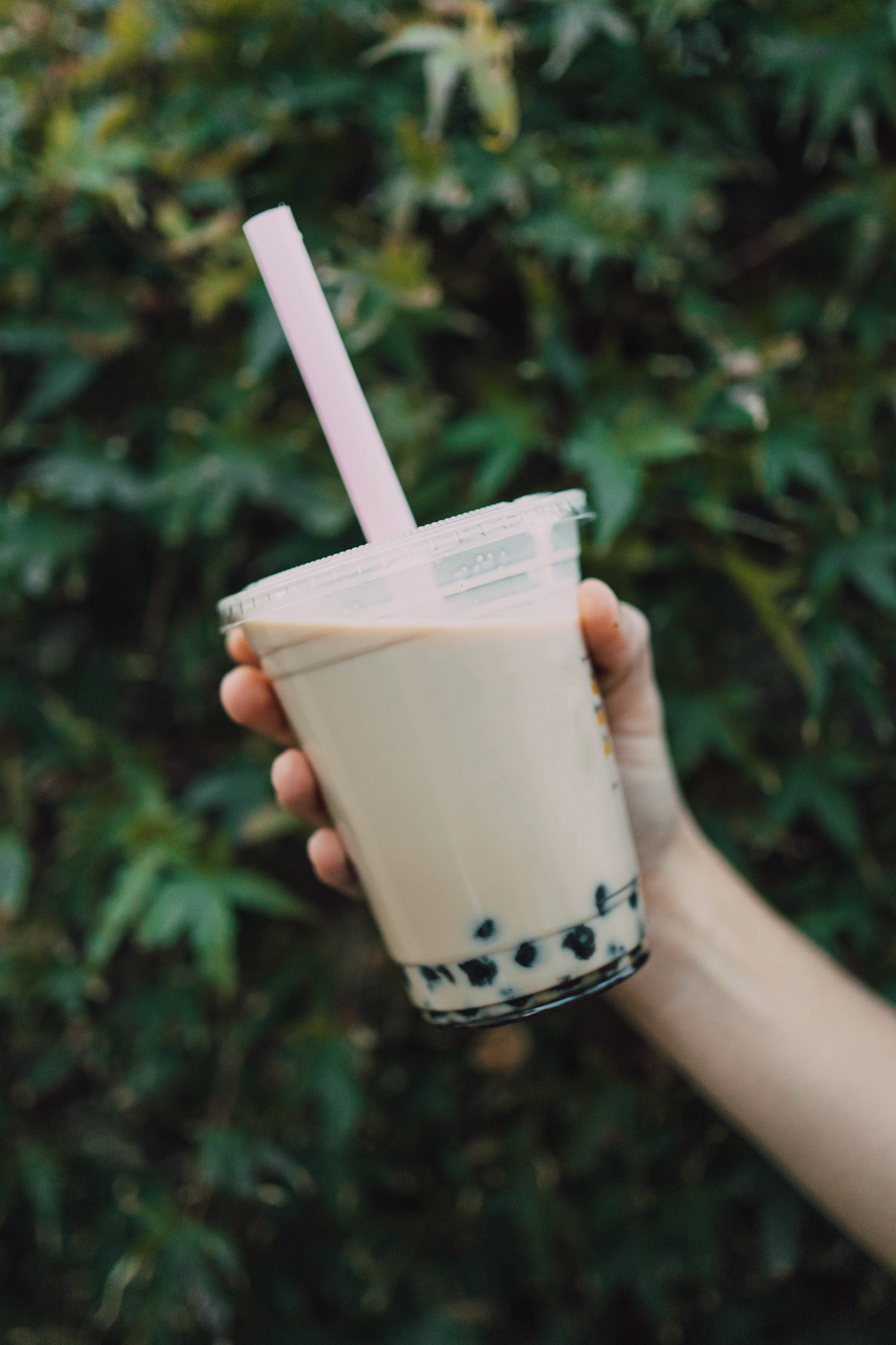 image of a person holding boba tea in a cup with straw