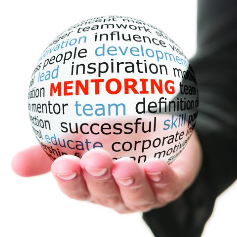 hand holding a clear ball featuring the word mentoring